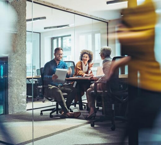 Diverse business team collaborating on AI enablement services strategy around a table